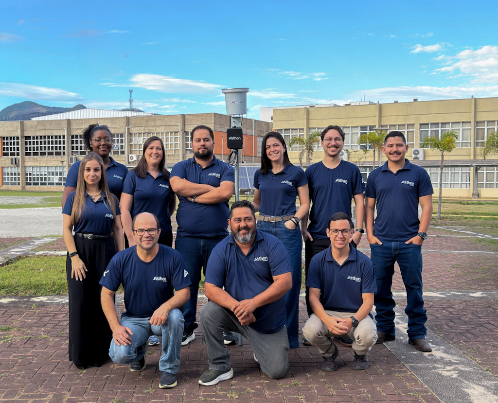 Equipe Asthon Tecnologia ao lado de uma estação de monitoramento
